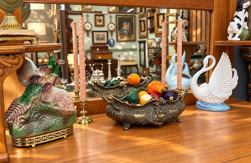 A pheasant, a bronze fruit bowl and a white swan on an oak sideboard