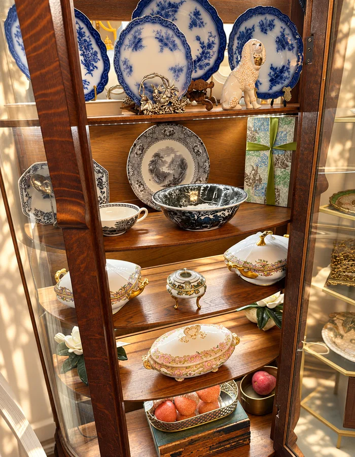 An oak curio cabinet of flow blue plates and transferware